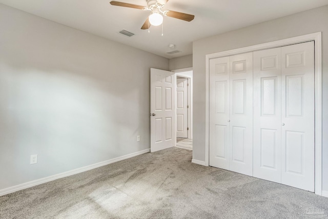 unfurnished bedroom with ceiling fan, a closet, and light carpet