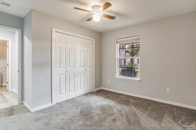 unfurnished bedroom featuring ceiling fan, light colored carpet, and a closet