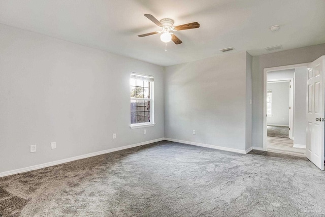 unfurnished room with ceiling fan and carpet