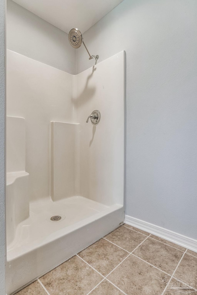 bathroom with walk in shower and tile patterned flooring