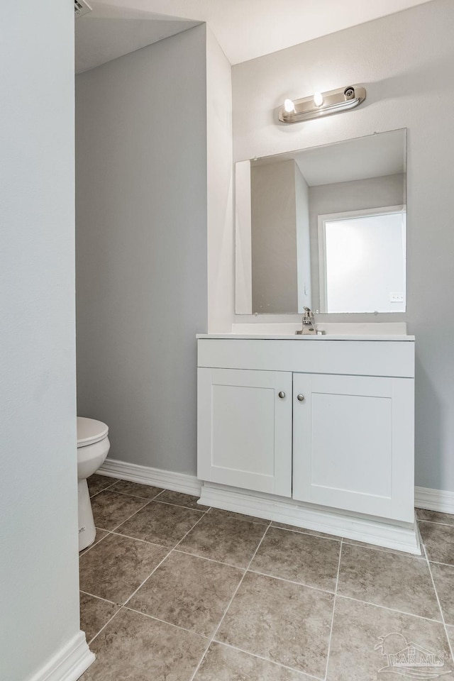 bathroom with tile patterned flooring, vanity, and toilet