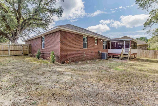 rear view of property featuring a sunroom and central air condition unit