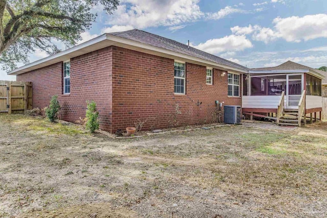 rear view of house featuring a sunroom and central air condition unit