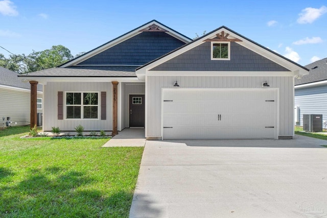 view of front of home featuring a front lawn, central AC unit, and a garage