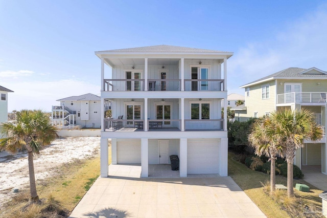 coastal inspired home featuring a garage, french doors, and a balcony