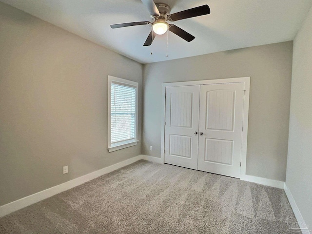 unfurnished bedroom with carpet floors, ceiling fan, and a closet