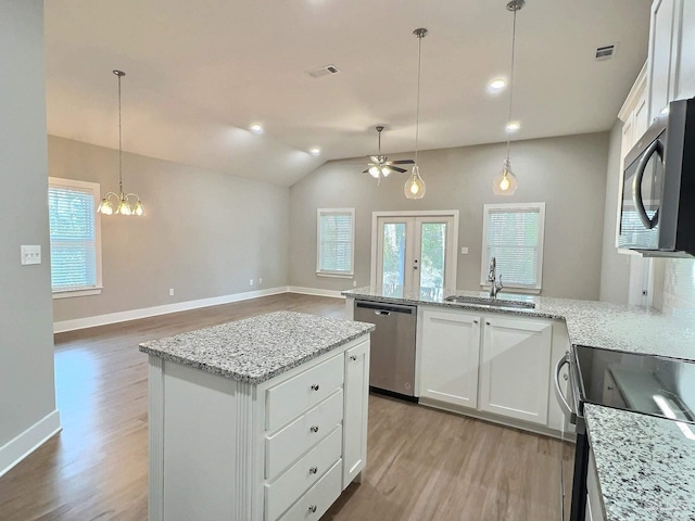 kitchen with white cabinetry, sink, dishwasher, and a kitchen island