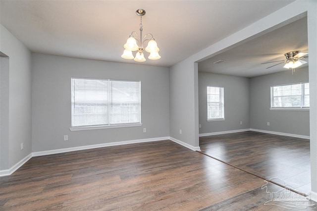 spare room featuring visible vents, baseboards, dark wood-style flooring, and ceiling fan with notable chandelier