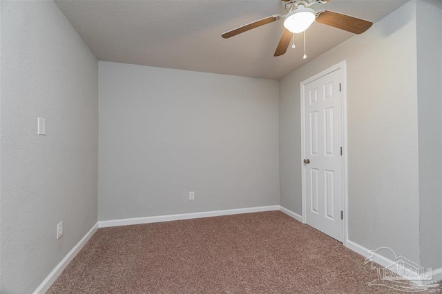 carpeted spare room with baseboards and a ceiling fan