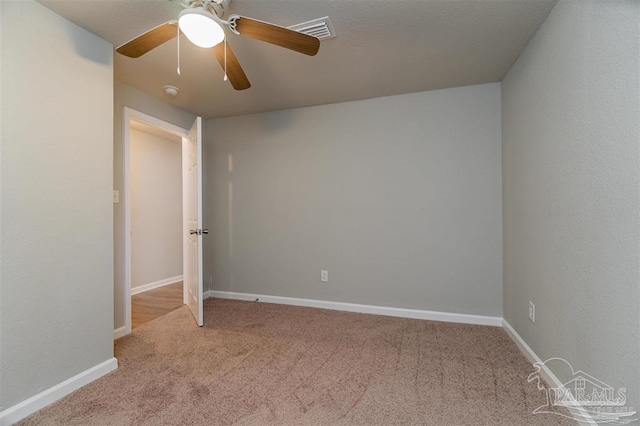 unfurnished bedroom featuring baseboards, visible vents, a ceiling fan, and light colored carpet