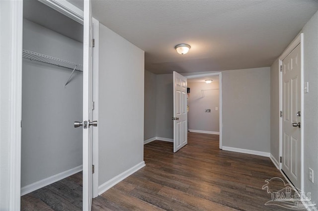 interior space featuring dark wood-style floors, a closet, and baseboards