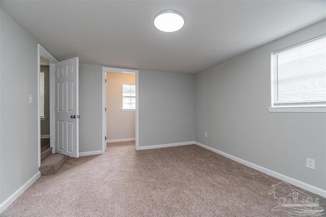 unfurnished room featuring carpet floors and baseboards