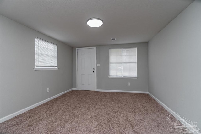 carpeted empty room with visible vents and baseboards