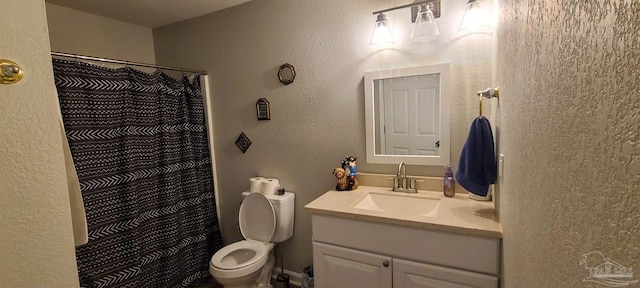 bathroom featuring toilet, a textured wall, vanity, and a shower with curtain