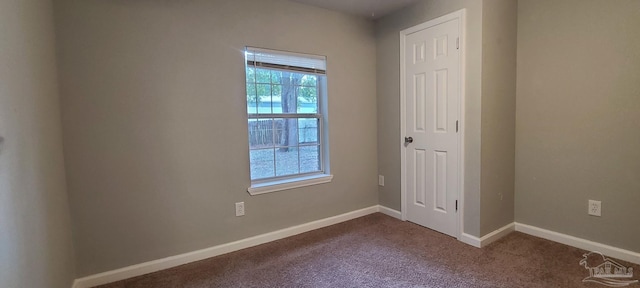 empty room with baseboards and carpet flooring