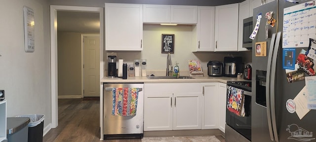 kitchen featuring white cabinets, appliances with stainless steel finishes, light countertops, and a sink