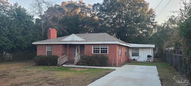 bungalow with brick siding, a chimney, a front yard, and fence