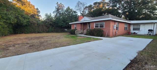 view of front of home with a front yard, a chimney, and brick siding