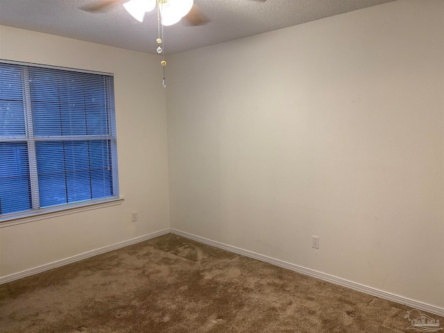 carpeted empty room with ceiling fan and a textured ceiling