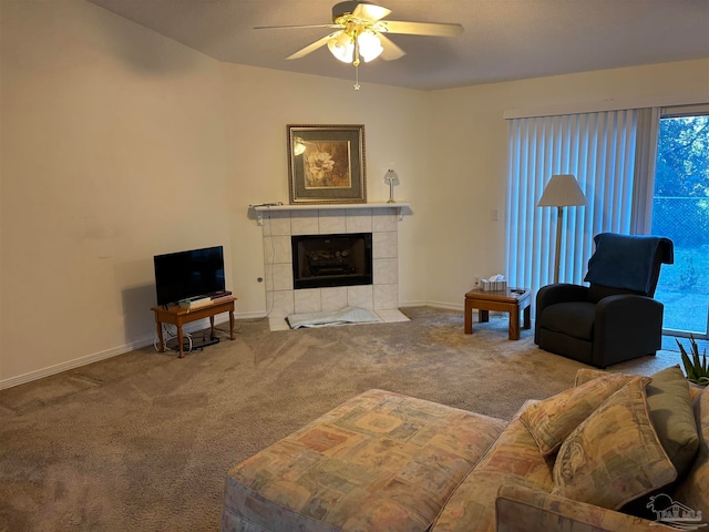 carpeted living room with ceiling fan and a fireplace