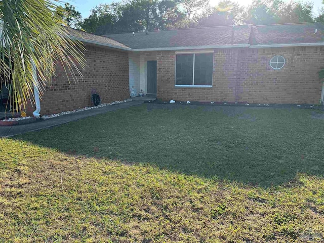 view of front of home with a front yard and brick siding