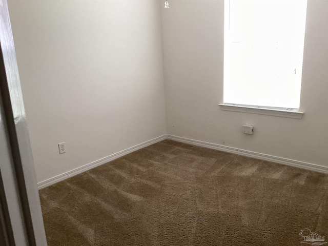 unfurnished room featuring carpet and baseboards