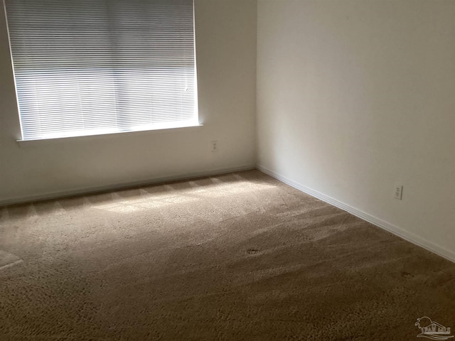 carpeted spare room with baseboards