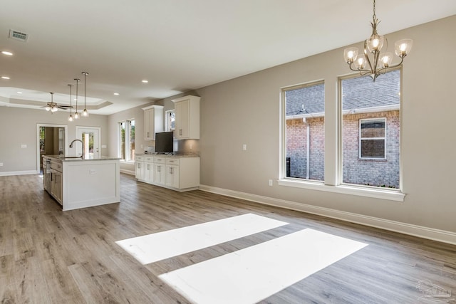 kitchen featuring pendant lighting, an island with sink, and a wealth of natural light