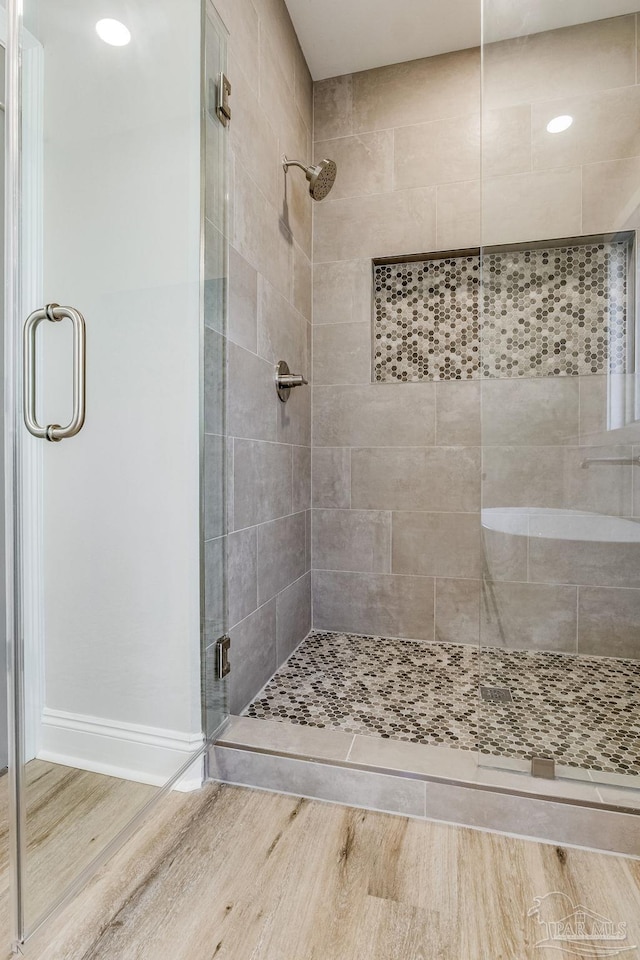 bathroom with walk in shower and hardwood / wood-style flooring