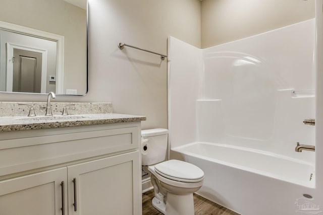 full bathroom with shower / tub combination, vanity, hardwood / wood-style flooring, and toilet