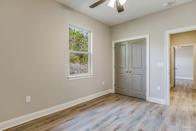 unfurnished bedroom with ceiling fan, a closet, and light hardwood / wood-style flooring