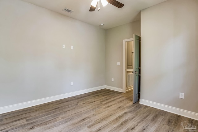 spare room with ceiling fan and light wood-type flooring