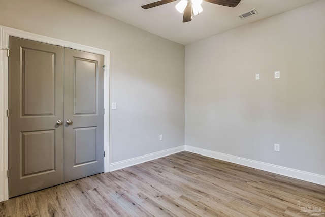 empty room with ceiling fan and light hardwood / wood-style floors