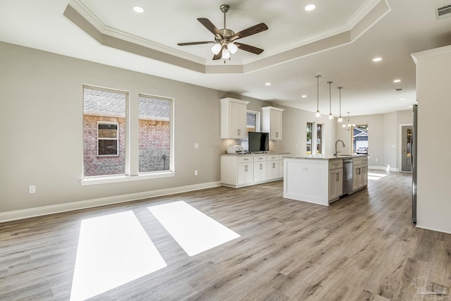 kitchen with hanging light fixtures, light hardwood / wood-style flooring, a kitchen island with sink, and a healthy amount of sunlight