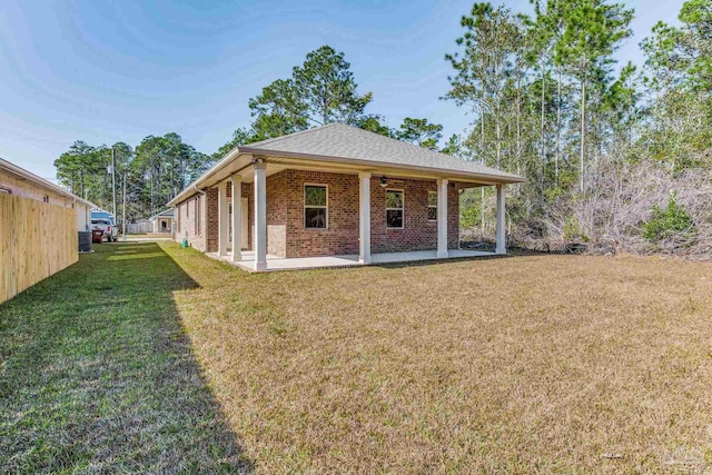 view of front of house with ceiling fan, cooling unit, a patio, and a front yard