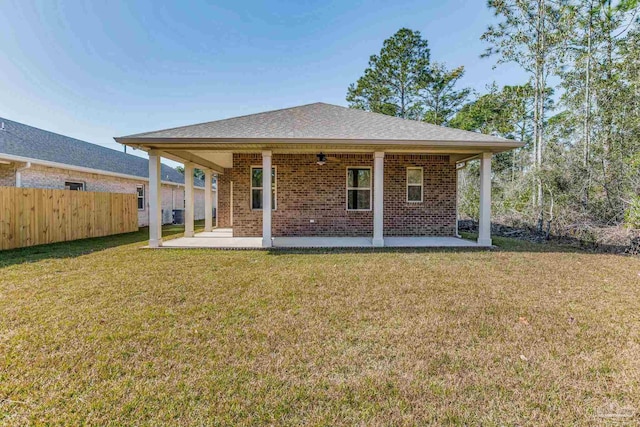 back of property with a yard and a patio