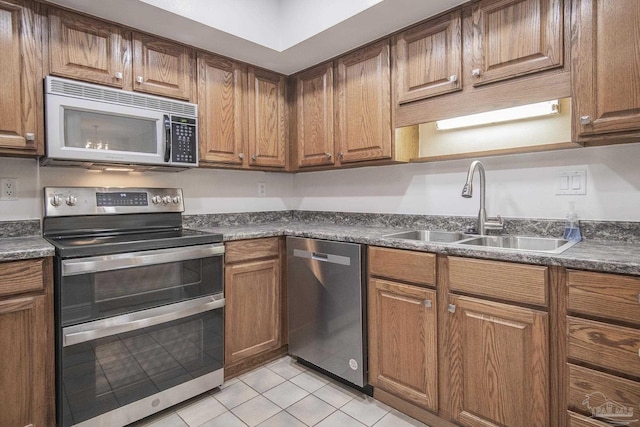 kitchen with sink, light tile patterned floors, and stainless steel appliances