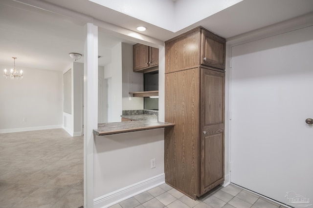 kitchen featuring an inviting chandelier, light tile patterned floors, and decorative light fixtures