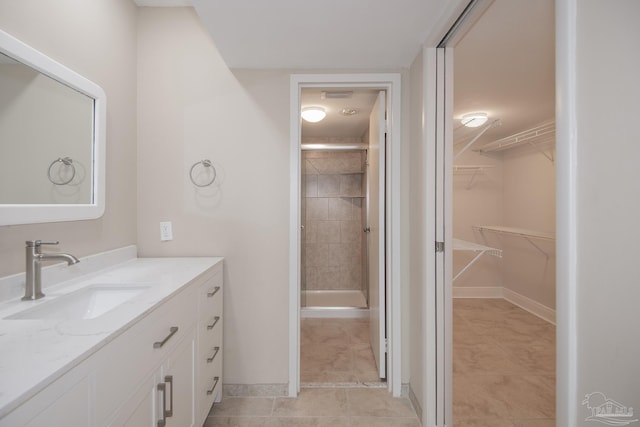 bathroom featuring vanity, tile patterned flooring, and tiled shower