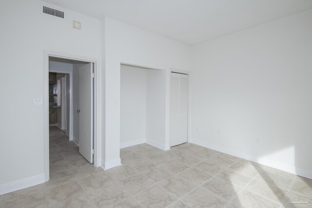 unfurnished bedroom with light tile patterned floors and a closet