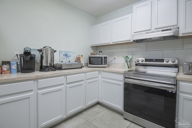 kitchen with white cabinetry, backsplash, stainless steel appliances, and light tile patterned flooring