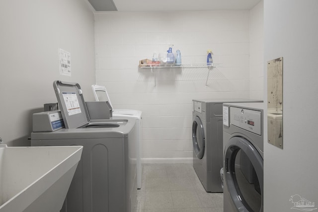 laundry room with washing machine and clothes dryer and sink