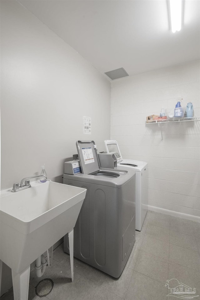 clothes washing area featuring independent washer and dryer and sink