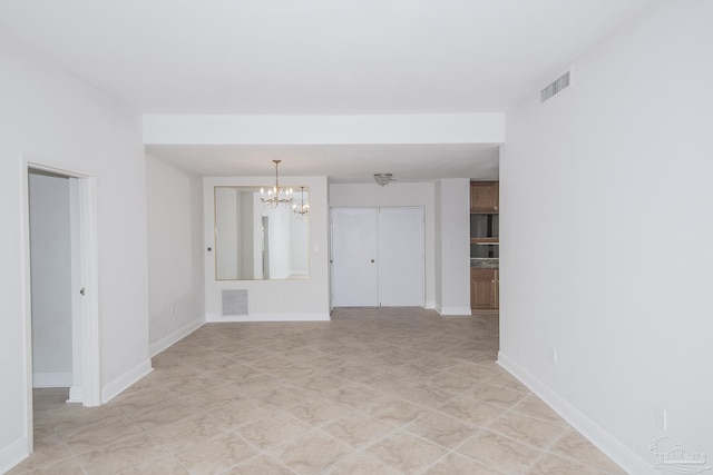 unfurnished room with a notable chandelier