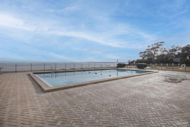 view of swimming pool with a patio and a water view