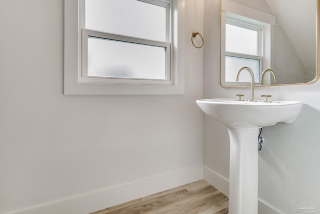 bathroom with lofted ceiling and wood-type flooring