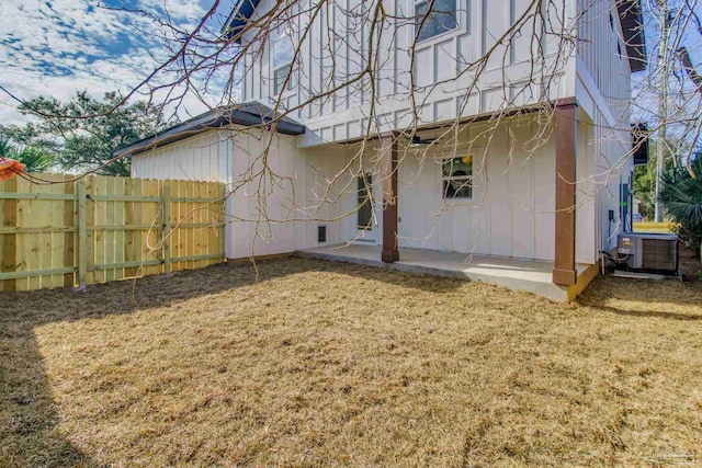 rear view of property with cooling unit, a lawn, and a patio