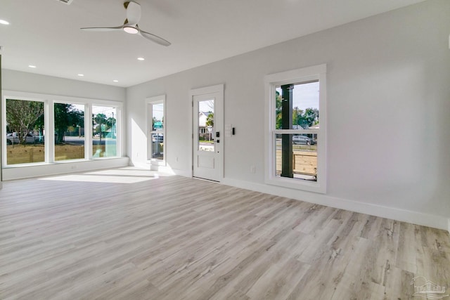 unfurnished living room with a wealth of natural light, light hardwood / wood-style flooring, and ceiling fan