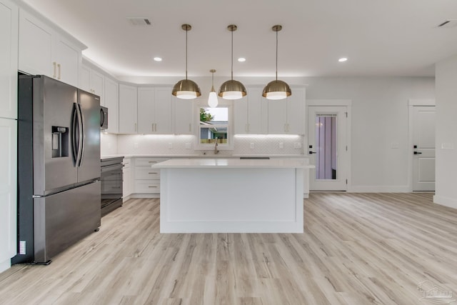 kitchen with white cabinetry, hanging light fixtures, stainless steel refrigerator with ice dispenser, a kitchen island, and decorative backsplash