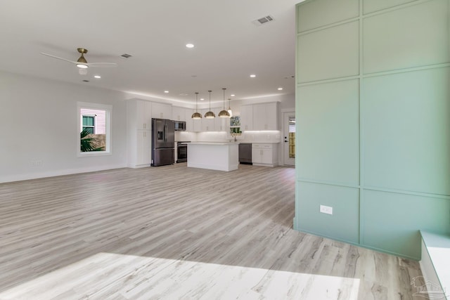 unfurnished living room with ceiling fan and light hardwood / wood-style flooring